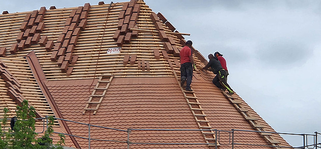 Šikmý kostel u Karviné mění barvu. Šedý eternit střídá oranžová bobrovka